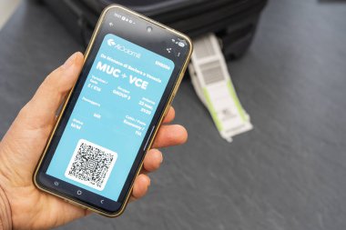 Venedik İtalya. Ağustos 2025. Elinde bavul ve Air Dolomiti dijital biniş kartıyla geziye çıkmak.