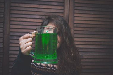 yeşil bira bir ahşap duvar karşısında bir barda bir fincan genç kadınla