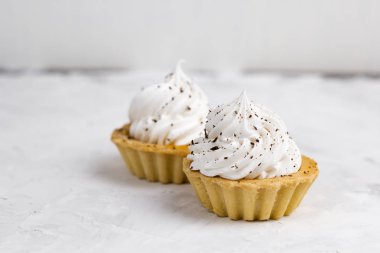 krema ile iki top kek çikolata parçaları beton arka plan ile dekore edilmiştir.