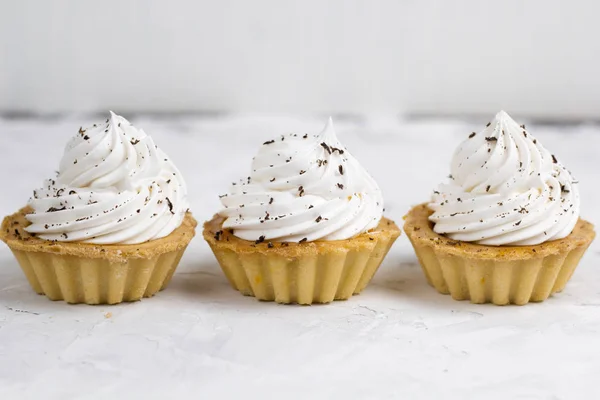 Kolme Cupcake Kerma Koristeltu Suklaa Sirut Konkreettinen Tausta — kuvapankkivalokuva