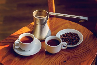 iki bardak kahve ve cezve masada.