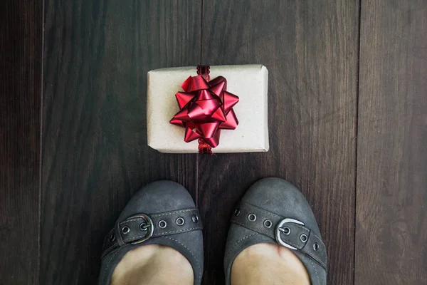 shoes and gifts on a background of dark parquet, a gift concept