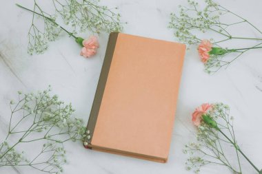 mermer bir zemin üzerine boş çarşafları ve çiçekler ile üst viewvintage kitap