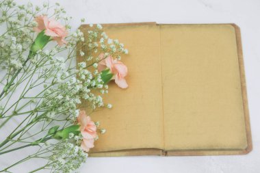 mermer bir zemin üzerine boş çarşafları ve çiçekler ile üst viewvintage kitap