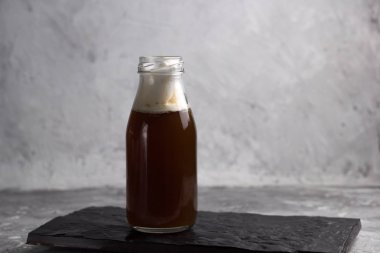 siyah bir taş plaka üzerinde cam şişede kahve içecek