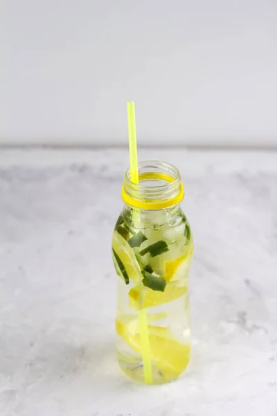 water with lemon ,cucumber and aloe vera  in bottle with cocktail straw copy space