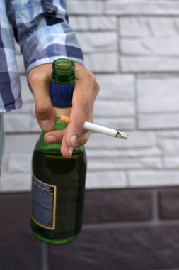 bira şişesi ve sigara ile genç adamın elini