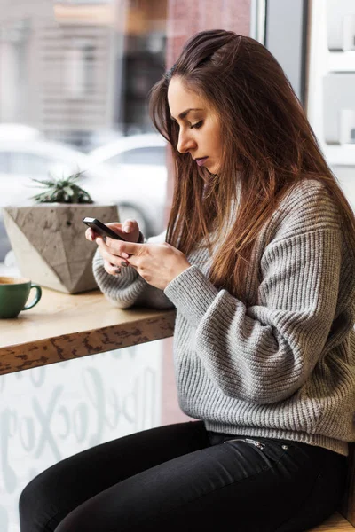 Hermosa Mujer Joven Suéter Gris Utilizando Teléfono Móvil Cafetería —  Fotos de Stock