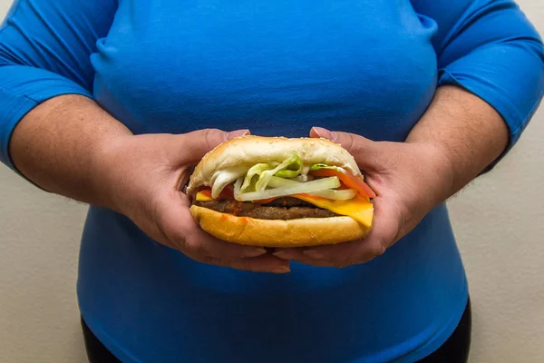 Obézní Žena Nosí Modré Tričko Drží Hamburger — Stock fotografie