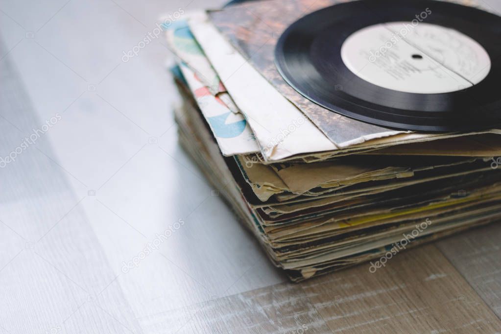 a stack of old vinyl records on a wooden floor