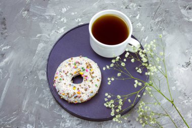 Üstten Görünüm kahve kupa, çörek bir plat Tarih ve çiçek bir beton zemin üzerine