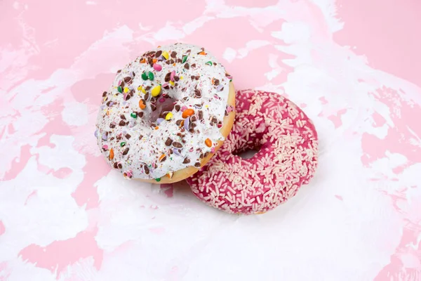 白色和粉红色背景上的甜甜甜圈 — 图库照片