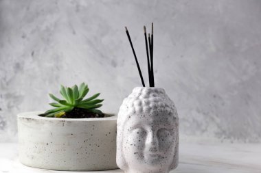 Buddha tütsü ile baş ve sulu bir beton zemin üzerine beton bir tencerede