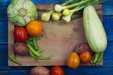 ahşap tepsi tepesinde taze organik tarım sebze sebze güveç vejetaryen gıda kavramı için arka plan malzemeler için mavi ahşap panoları görüntülemek