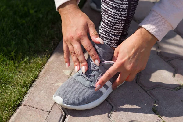 woman tying laces, select footwear for the sport, preparing for the workout