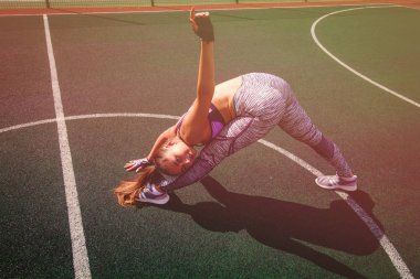 güzel genç atletik kız açık basketbol sahası, spor, sağlıklı yaşam konsepti üzerinde uzanan yapıyor