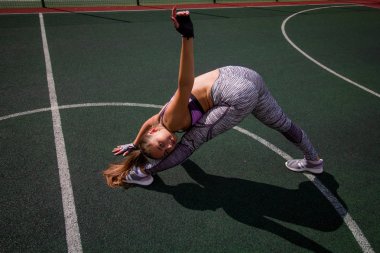güzel genç atletik kız açık basketbol sahası, spor, sağlıklı yaşam konsepti üzerinde uzanan yapıyor
