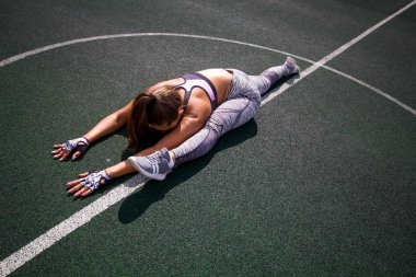 güzel genç atletik kız açık basketbol sahası, spor, sağlıklı yaşam konsepti üzerinde uzanan yapıyor