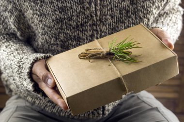 tarçın ve Ladin adamın elinde bir delikanlı süslenmiş şirin el yapımı hediye kutusu