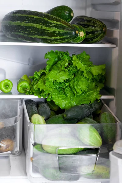 open fridge shelves and drawers full of green vegetables, raw food, veganism, healthy food, healthy lifestyle, food storage concept