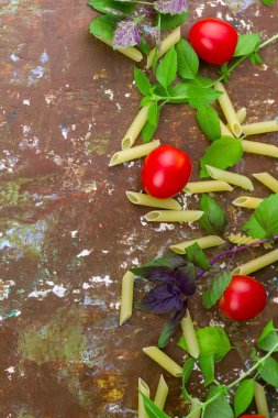 küçük olgun domates, taze fesleğen, makarna üstten görünüm düz yatıyordu çerçeve kahverengi eski püskü arka plan recepies veya ürün yerleştirme yemek pişirmek için boş alan ile