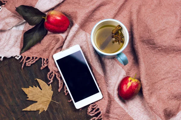 Üstten Görünüm telefon ile boş siyah perde ve sıcak baharatlı elma çayı