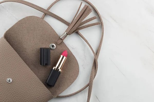 Üstten Görünüm ruj mermer masada açık bir çanta içinde