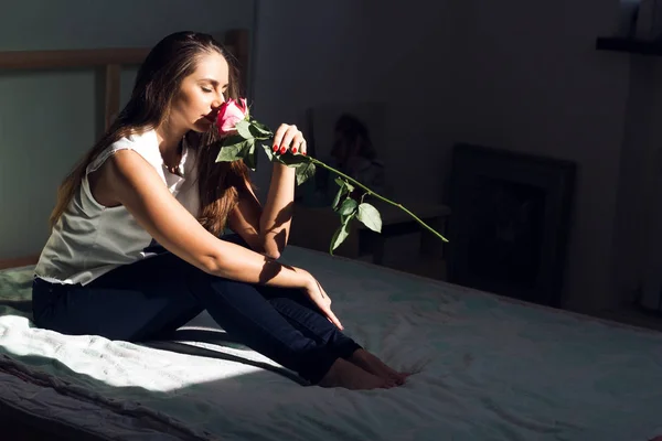 Kapalı gözlerle yatakta gül gül, kadın nefes kokusu ile yatak odasında oturan genç beyaz kadın