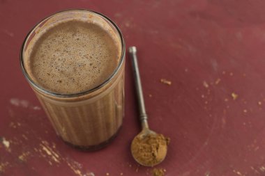 kahverengi berbat ahşap masada üst görünüm sıcak tatlı ev yapımı kakao ve kuru kakao tozu kaşığı
