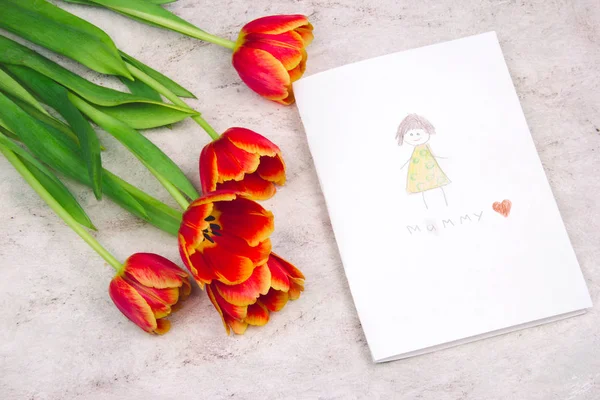 beautiful tulips and handmade card with kid\'s drawing  for Mother\'s Day on marble background, top view