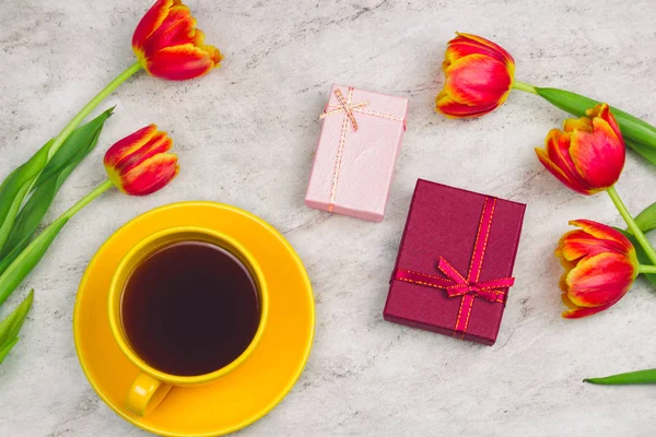 flat lay gift boxes , coffee cup and tulips on a marble background