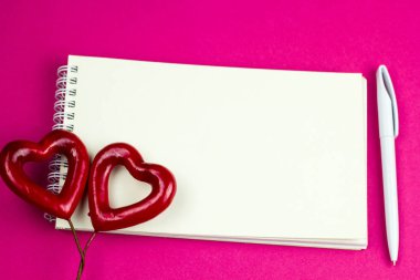 Üstten Görünüm boş beyaz bir kağıt yaprağına ve kalem kalem ve iki kırmızı kalp ile