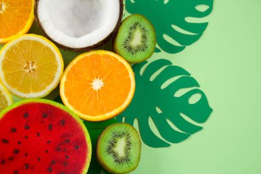 üst görüntüleme çeşitli meyve ve yeşil bir arka plan üzerinde monstera kağıt yaprakları