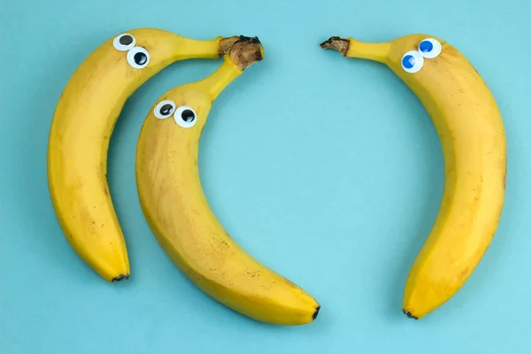 Três Bananas Com Olhos Googly Vista Superior Sobre Fundo Azul — Fotografia de Stock