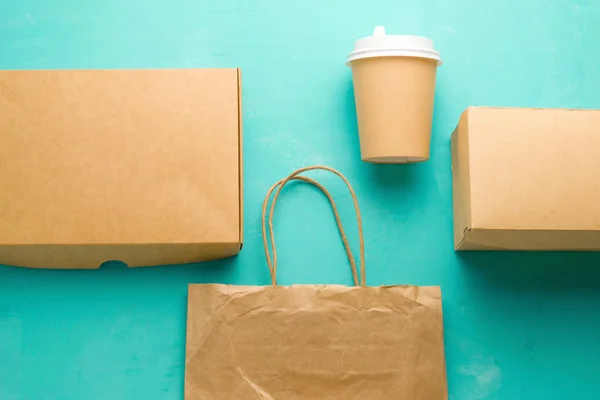 top view flat lay recyclable types of paper  packaging on a blue background, paper bag, disposable glass, cardboard box