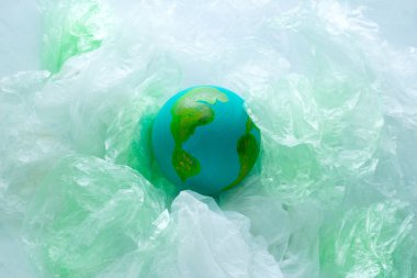 plastik torbalar arasında Dünya gezegeninin küçük bir model üst görünümü, çevre, küresel kirlilik kavramı, dünya günü