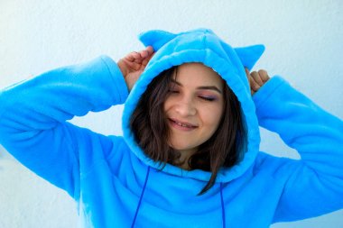 kabarık mavi pijama veya kedi kostümü sevimli genç esmer kadın başlık üzerinde kostüm kulakları dokunur
