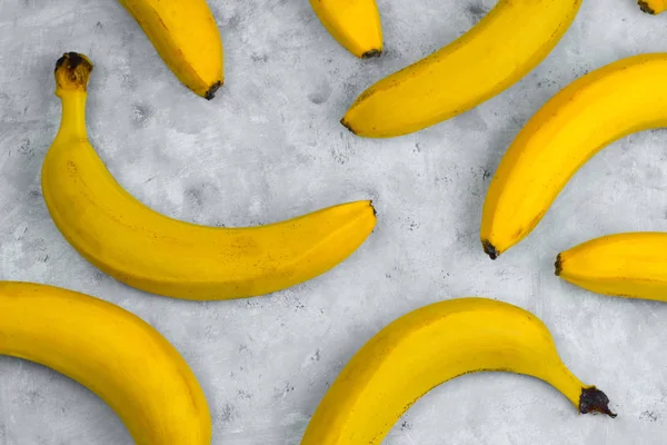 灰色の背景に新鮮な黄色のバナナのパターン — ストック写真