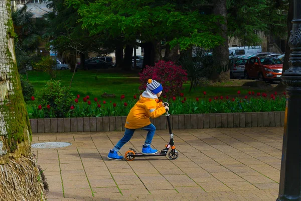 Sochi Russia April 2019 Boy Bright Yellow Jacket Riding Scooter — Stock Photo, Image