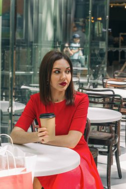 bir kahve dükkanında kırmızı elbise içme kahve genç güzel esmer kadın