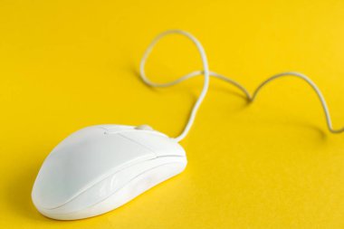 Beyaz bilgisayar faresi sarı arkaplan seçici odak üzerinde izole