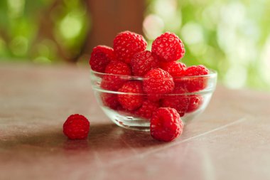 kahverengi bahçe masa arka plan üzerinde ahududu dolu cam kase