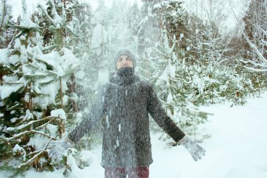 karlı kış parkı düşen kar altında mutlu yakışıklı genç adam
