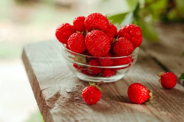 ahşap bahçe masa arka plan üzerinde çilek dolu cam kase