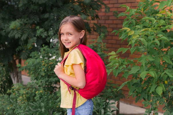 Portrait Beautiful Little Girl Backpack Background Brick Wall Green Bushes — Stock Photo, Image