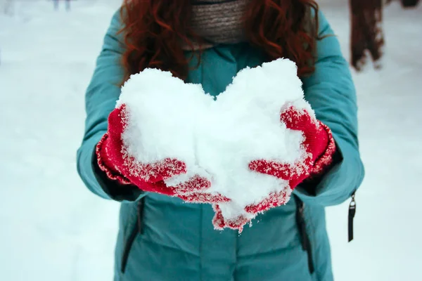 在雪雪的冬季公园里 女人抱着雪做成的心 — 图库照片