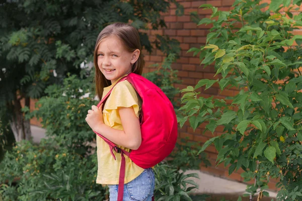 Portrait Beautiful Little Girl Backpack Background Brick Wall Green Bushes — Stock Photo, Image