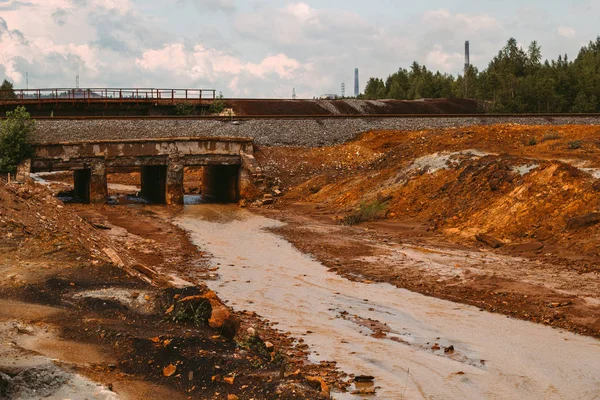 landscape with landscape with red water and soil  polluted by copper mining factory in Karabash, Russia, Chelyabinsk region, the dirtiest city on Earth