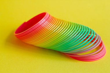 Sarı bir arka plan üzerinde izole oyun için oyuncak plastik renkli gökkuşağı spiral