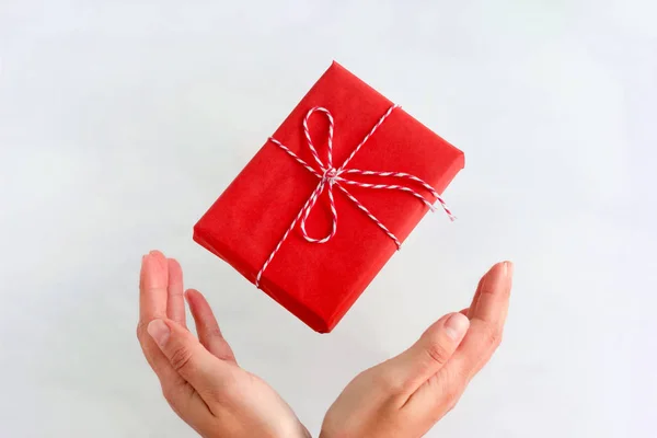 Handgemachte Rote Geschenkschachtel Fliegt Weibliche Hände Auf Weißem Hintergrund — Stockfoto